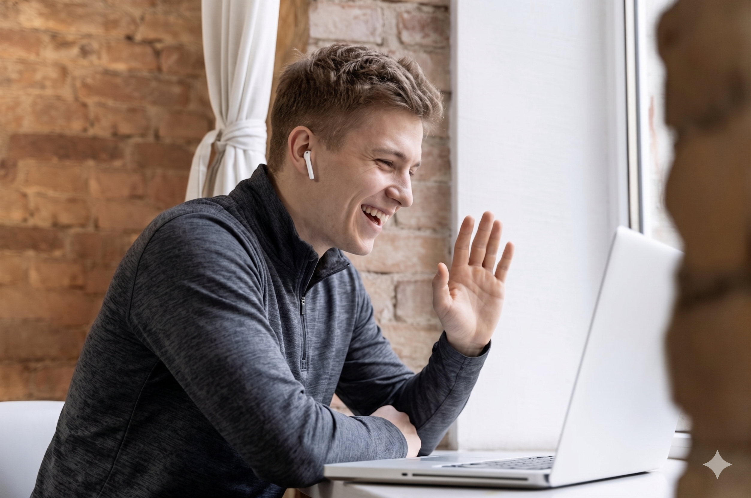 Professional waving hello during a video call on a laptop